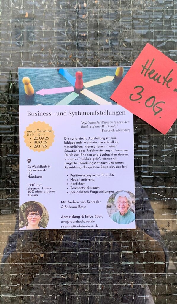 Ein Flyer für "Business- und Systemaufstellungen"-Workshops mit Terminen und Kontaktdaten, aufgeklebt an einer Glastür neben einem roten Zettel mit der Aufschrift "Heute 3. OG.