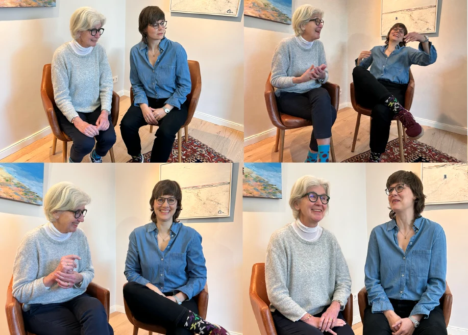Eine Collage aus vier Fotos zeigt zwei Frauen, die auf Stühlen in einem gemütlichen Raum sitzen, lächeln, lachen und sich unterhalten. Eine Frau hat kurzes graues Haar und eine Brille, die andere hat kurzes braunes Haar und eine Brille.